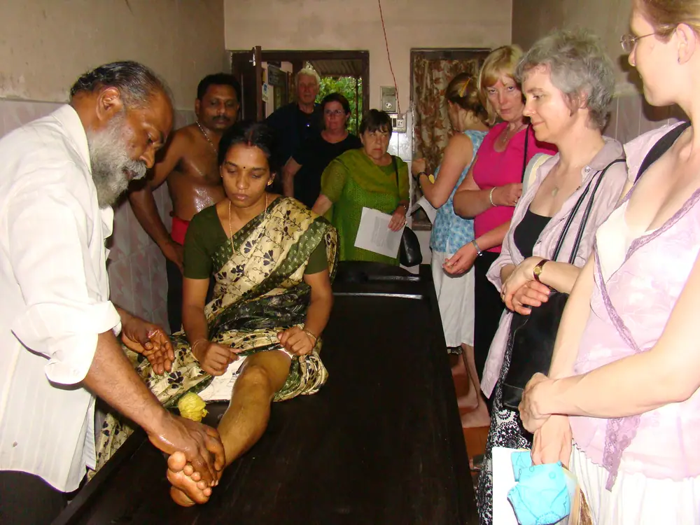 A therapist demonstrating a kizhi herbal-bolus treatment