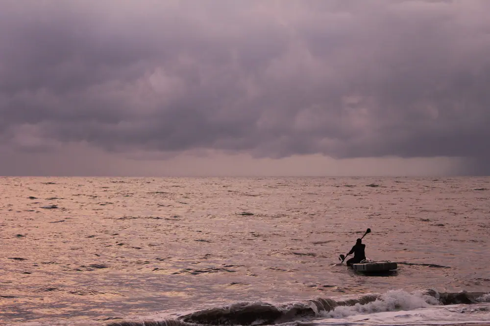 A fisherman’s boat in the surf off Marari beach at dusk