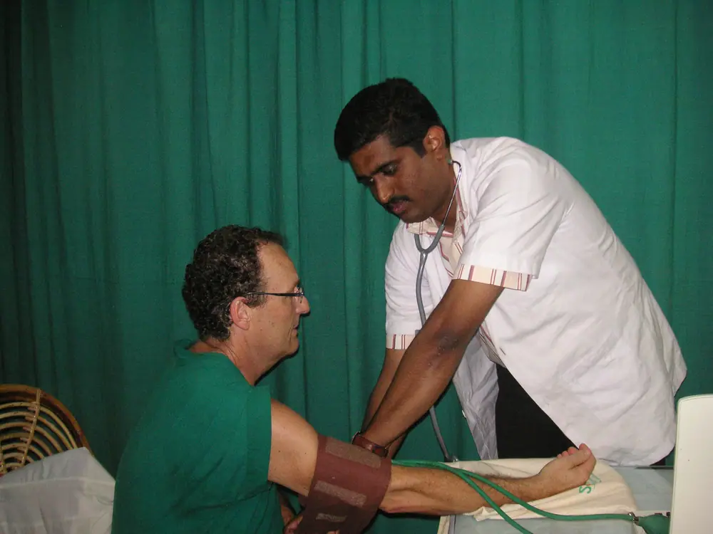 An Ayurveda doctor taking a guest’s pulse and blood pressure during a cure in Kerala